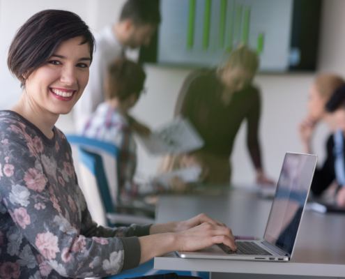 A young employee smiling confidently in a professional workplace.