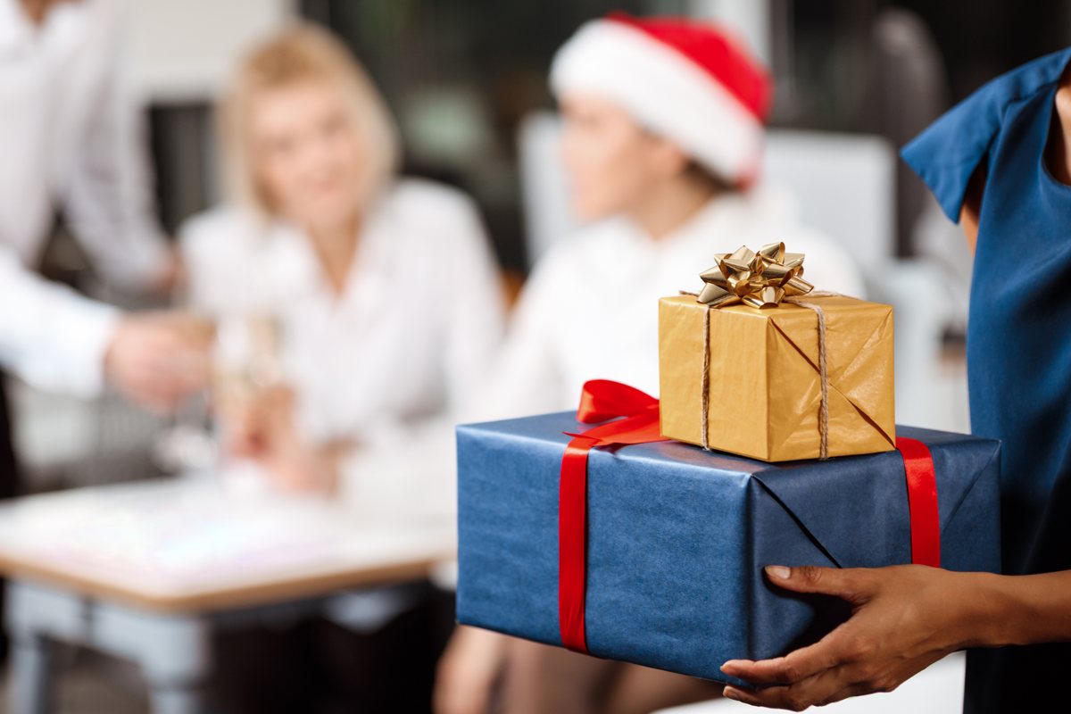 Christmas party tax Employee holding wrapped christmas gifts at an office party
